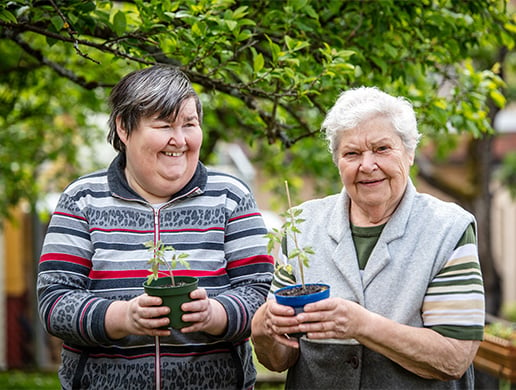 two women holding plants